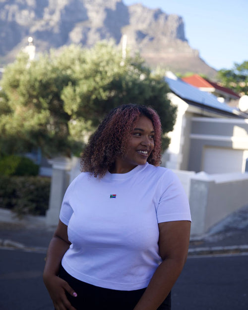 Female wearing a white SA T-shirt in front of Table mountain