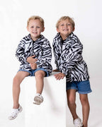Two children wearing the Kids Safari animal print jerseys in leopard print
