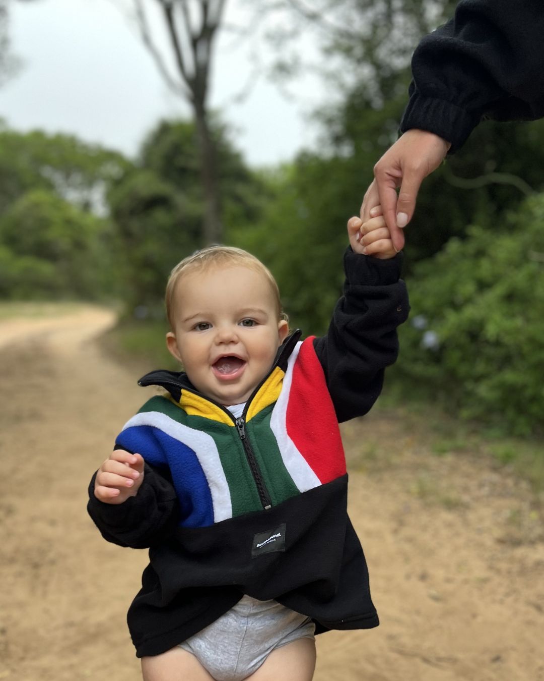 Baby walking in a Kids polar fleece SA flag jersey colour black