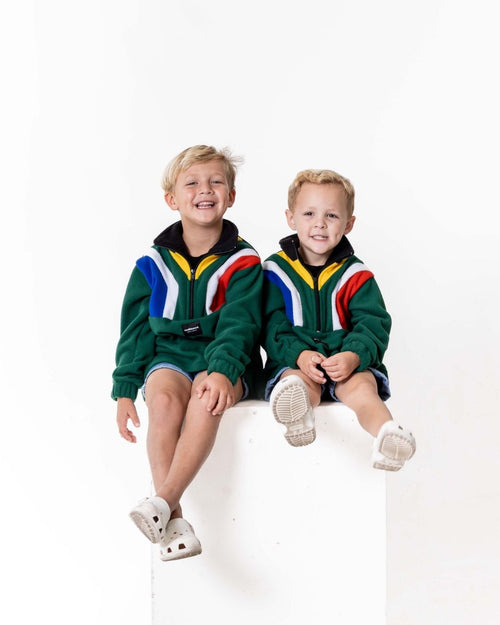 Two children wearing the Kids polar fleece SA flag jerseys in the colour green