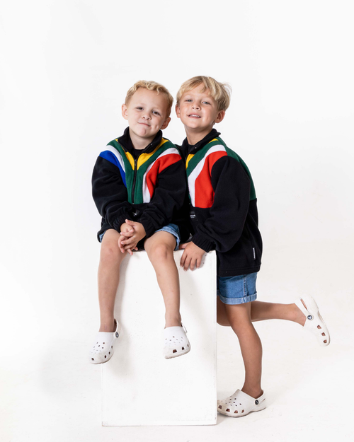 Two boys wearing the Kids polar fleece SA flag jerseys in black 