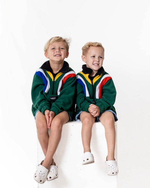 Two children wearing a Kids polar fleece SA flag jersey in the colour green