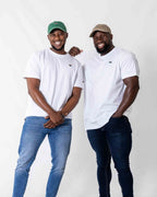 Two males wearing a white oversized T- shirt in front of a white backdrop