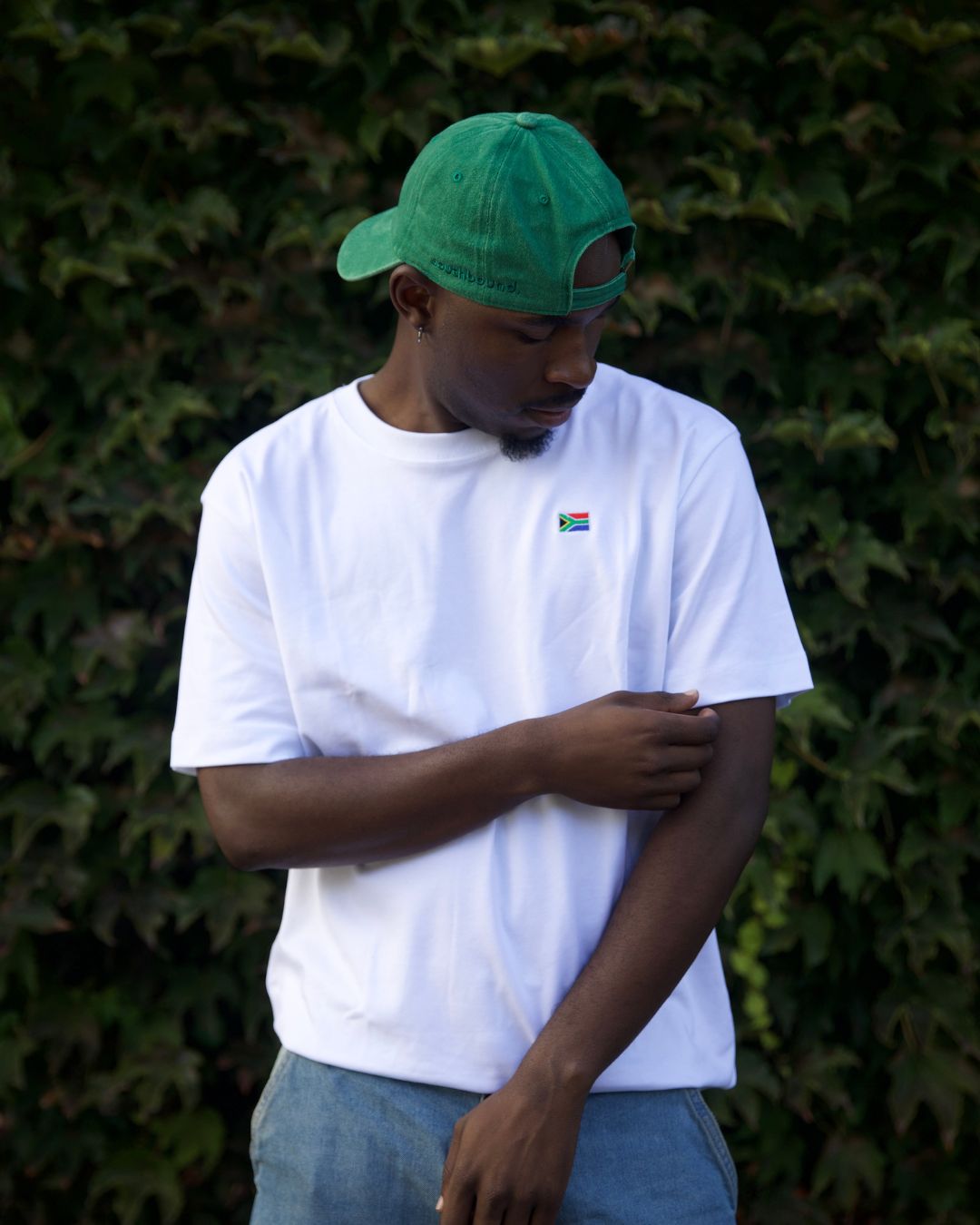 Male wearing a white Oversized SA T- Shirt outdoors