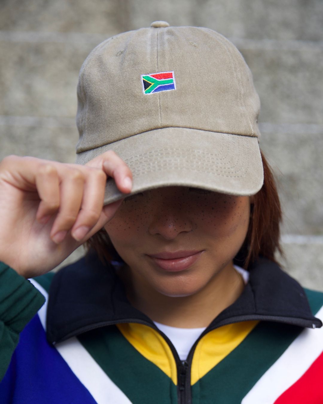 Female wearing a beige SA flag cap