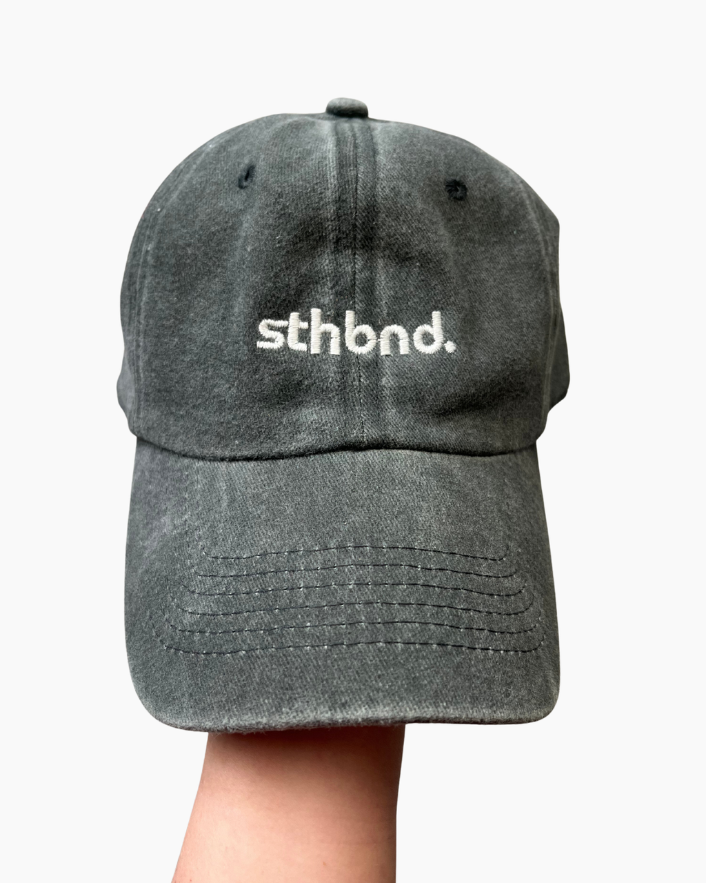 female holding a khaki/ charcoal sthbnd cap 
