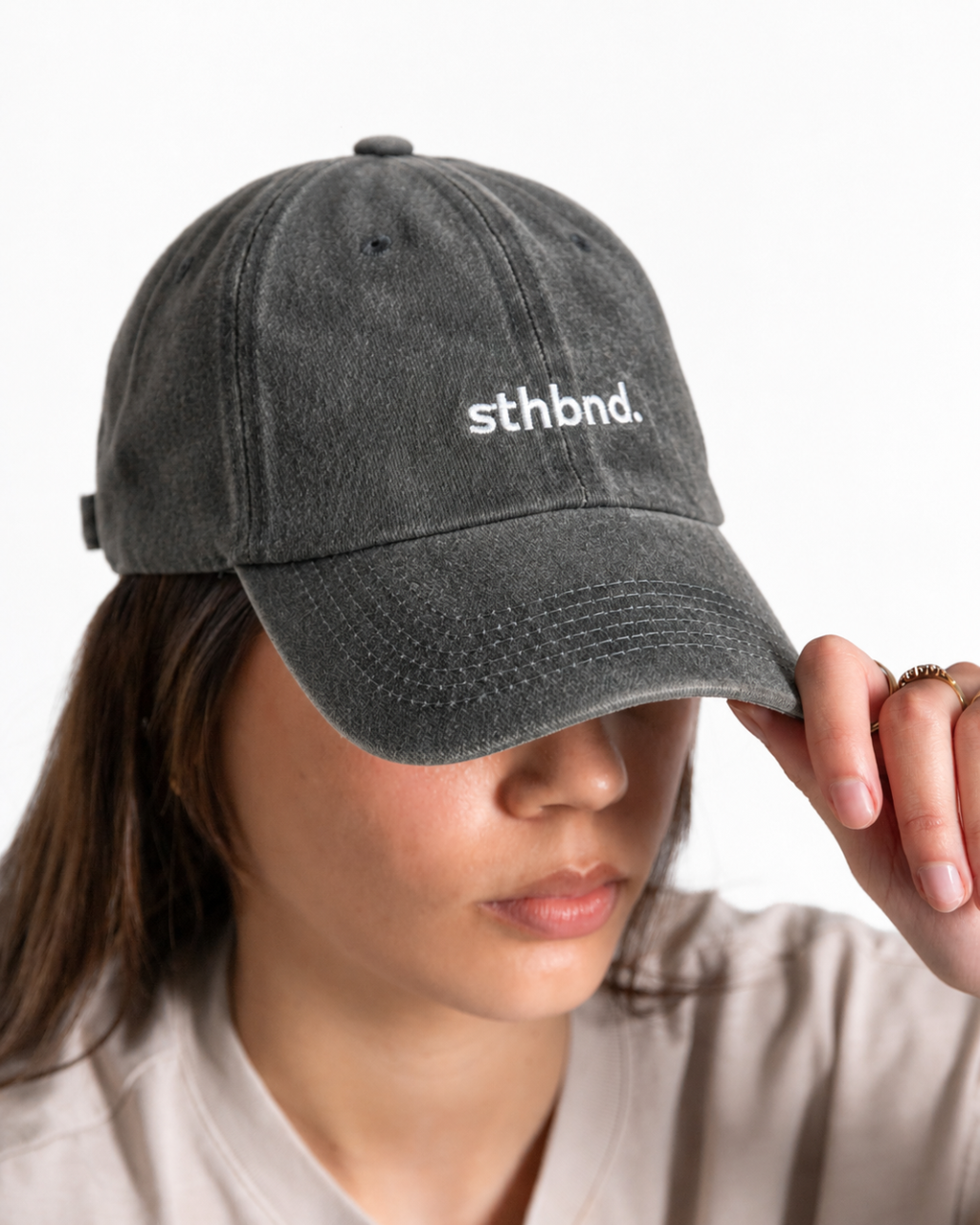 Female wearing a charcoal/ khaki cap wth the sthbnd logo on the front